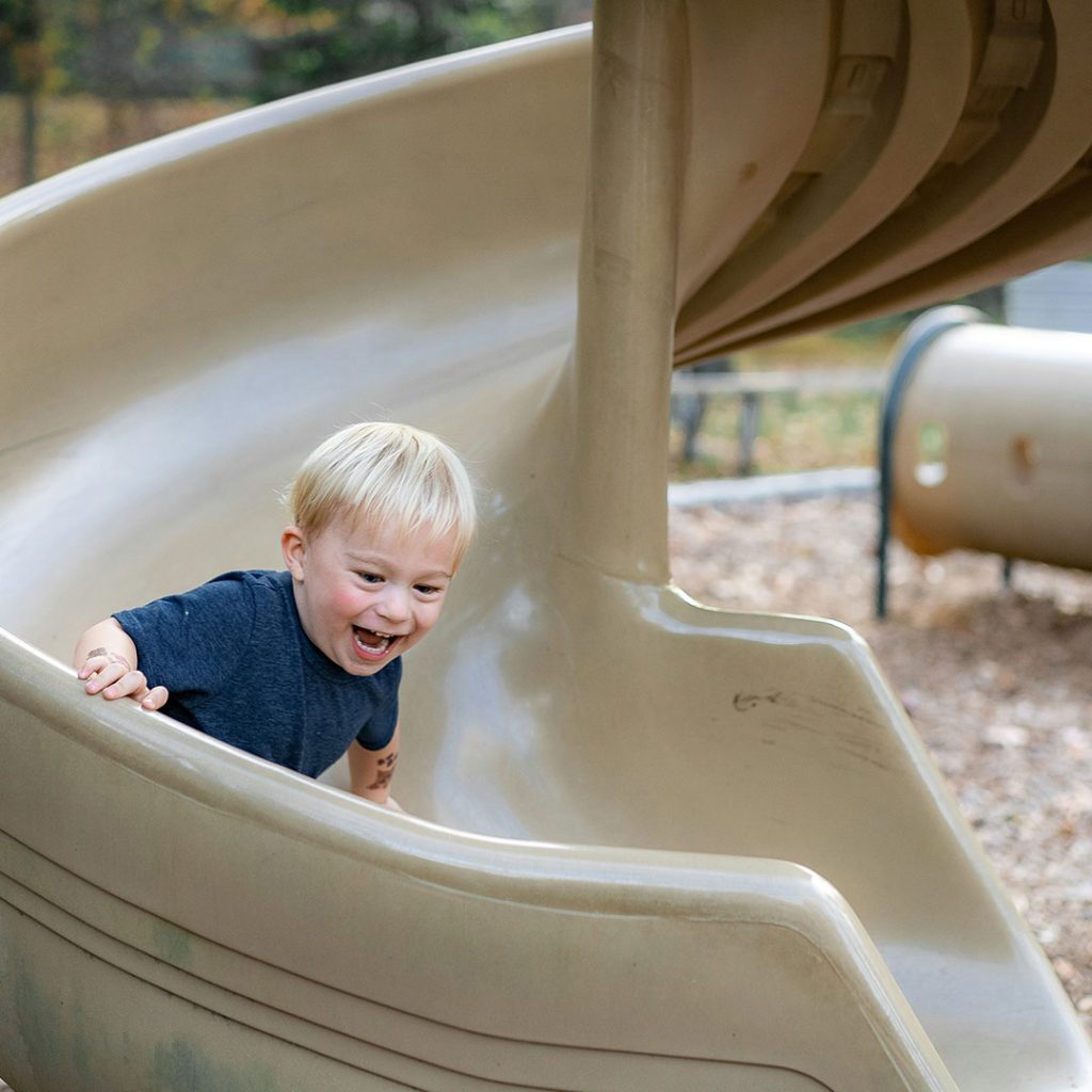Child playing on a slide in Outdoor Playscape